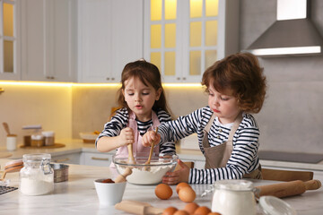 Cooking recipe. Cute children making dough for cookies at table in kitchen