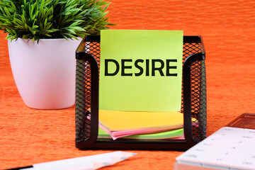 Desire text concept. DESIRE word, text written on a green sticker next to office supplies on an...