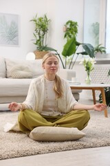 Feng shui. Young woman meditating on floor at home