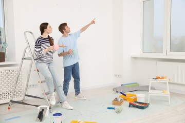 Couple with cups of coffee having break during renovation at home