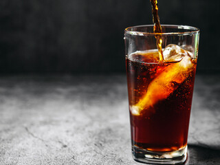 Pouring of Cola and Ice, Cola soft drink with ice cubes, soda fizzy drink in Cold glass