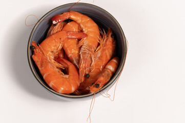 Shrimp in a blue bowl on a white background. Gambas on a white background, seafood.