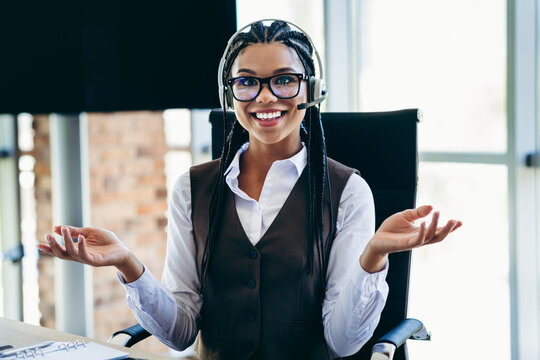 Smiling customer service operator working in an office environment wearing professional attire with a headset