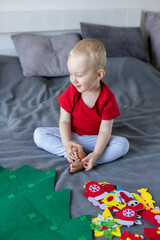 Happy child decorating toy Christmas tree. Educational games for children.