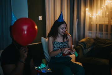 Group of friends enjoying a casual birthday celebration at home with festive decorations.