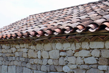 Toiture en tuiles canal ou romane avec crochet sur la grange en pierre