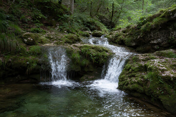 Obraz premium Lush valley with small waterfalls and moss covered rocks creates serene atmosphere