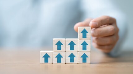 A person is holding a stack of wooden blocks with blue arrows on them