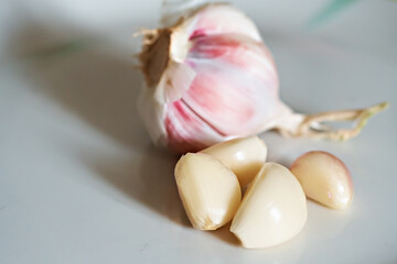 Garlic bulb and cloves. Garlic bulbs with cloves on a white plate. Composition of white garlic bulbs. Selective focus