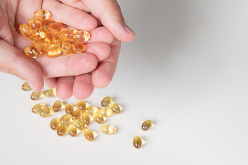 Fototapeta premium Abundance of Golden Softgel Capsules in Hands