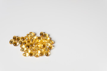 Scattered Golden Softgel Pills on White Surface

