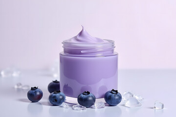 A jar of purple-colored natural cosmetic cream and a few blueberry berries on a light, neutral background
