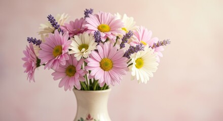 Fototapeta premium A charming bouquet of pink and white daisies interspersed with lavender sprigs sits in a delicate, patterned vase against a soft pink background. 