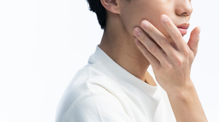 顎に手をあてている若いアジア人男性の横顔。 © lielos