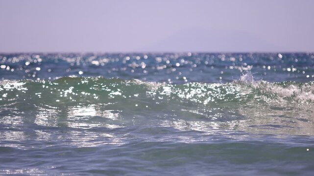 Crystal-clear sea waves sparkling under summer sunlight