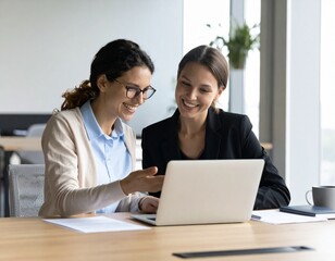 Obraz premium Smiling colleagues or company workers, two happy professional business people team talking at meeting using laptop computer discussing online ai project together working in office at workplace.