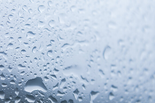 Close up of raindrops falling on glass windows