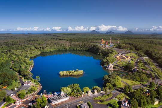 Aerial view of a tranquil lake mirroring the azure sky, nestled amidst verdant forests near the sacred Ganga Talao, Grand Bassin, Mauritius.