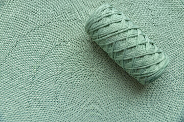 Home spiral double crochet in circle cap mint color background with a roll of yarn