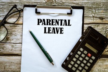 PARENTAL LEAVE written on a document. A beautiful wooden desk. 