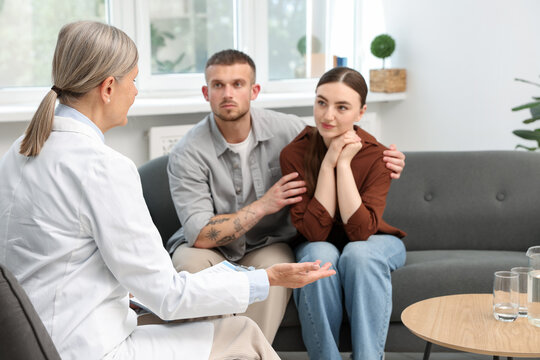In vitro fertilization (IVF). Upset couple having consultation with doctor in reproductive clinic