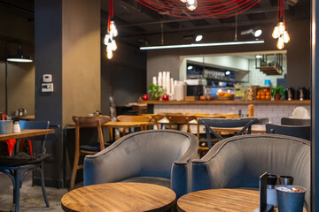 Modern cafe interior with soft warm lighting, minimalist furniture, and cozy lounge chairs