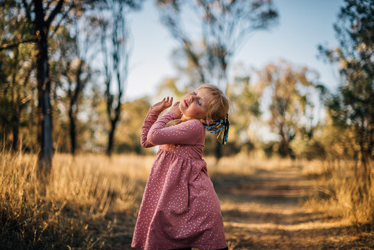 Young girl dancing outside in bushland