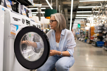 Woman engaged in thoughtful shopping experience at a retail store exploring home appliances and...