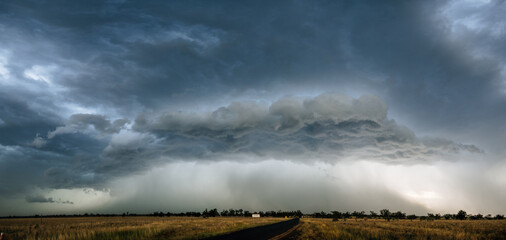 A large, ominous storm cloud formation over an expansive landscape.