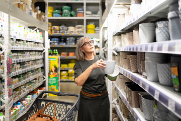 Woman selecting items in a home goods store while engaging with her shopping experience