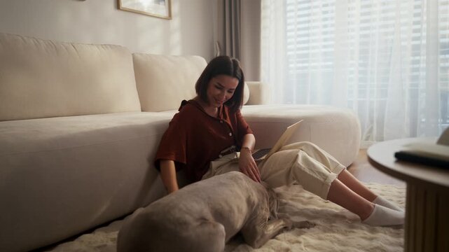 A Woman Happily Enjoying Quality Time with Her Dog at Home in a Cozy Living Room