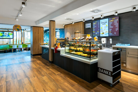 Modern McCaf&eacute; interior with a pastry display and digital menu board in Vienna, Austria,