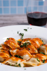 Ravioli pasta with tomato sauce and parsley sprinkled on top. Vertical Orientation