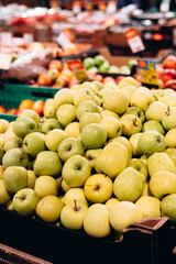 Pile of farm apples in supermarket display, imperfect natural fruits.