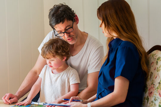 Speech pathologist filling out form chatting with young childs dad