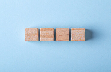 wooden pieces on blue background, copy space for 4 letter word