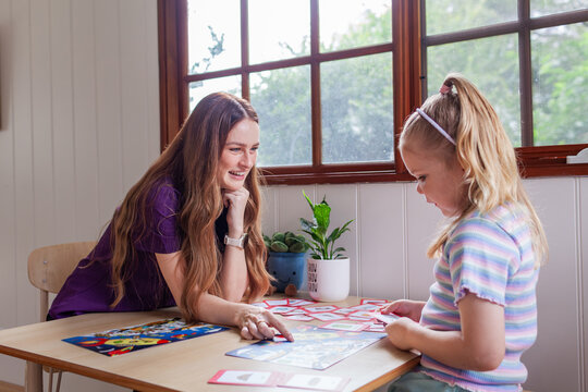 Child with speech disability looking at sound cards talking with speech-language pathologist