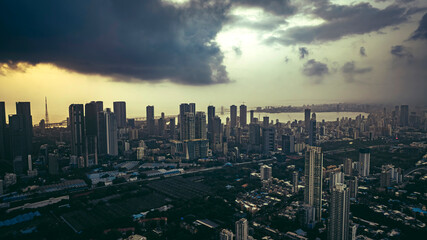 Aerial cinematic image of Mumbai during the monsoon season, featuring dramatic clouds and a glowing sunset over the city skyline. Aerial view of the Bandra-Worli Sea Link in Mumbai, India.