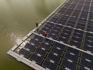 Professional workers clean and inspect solar panels on a floating buoy. Power plant with water	
