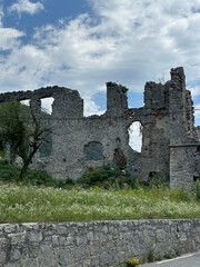 Ruins of an old European castle with weathered stone walls and medieval architecture, surrounded by...