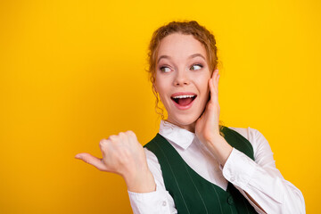 Cheerful Student Expressing Surprise in Stylish White Shirt and Green Vest on Vibrant Yellow...