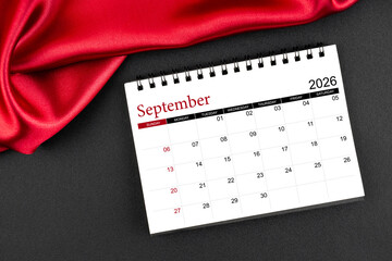 September 2026 Monthly desk calendar with red silk on black color leather background.