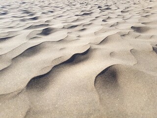 Close-up of desert sand wave formations with sharp and blurred textures