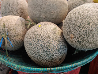 Pile of ripe cantaloupe melons on the bamboo wicker 