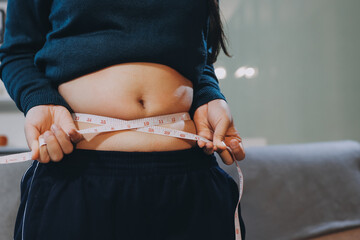 woman's hand holding excessive belly fat, overweight concept
