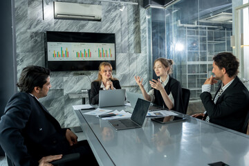 multiracial group of business people discussing report data during meeting inside modern office with technology device teamwork presentation for office work and business collaboration concept