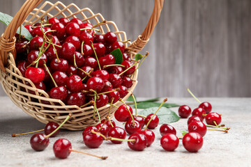 Wet ripe cherries in basket on light table, closeup