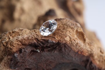 One beautiful shiny diamond on wood, closeup
