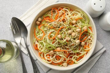 Tasty vegetable noodles with chickpeas served on grey table, flat lay. Vegetarian dish