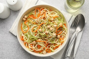 Tasty vegetable noodles with chickpeas served on grey table, flat lay. Vegetarian dish